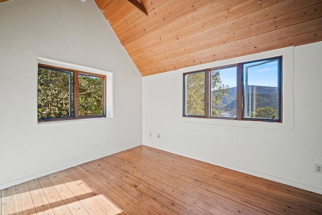 spare room featuring vaulted ceiling, wood ceiling, light hardwood / wood-style floors, and plenty of natural light