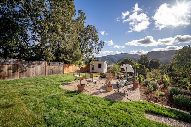 view of yard with a storage unit, a patio area, and a mountain view