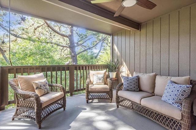 sunroom with ceiling fan and beam ceiling