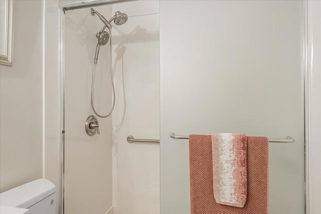 bathroom featuring toilet and an enclosed shower