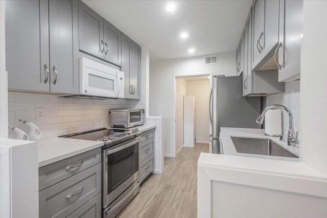 kitchen featuring gray cabinets, stainless steel electric stove, and sink