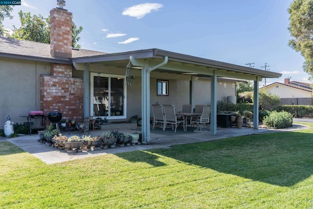 back of property with a lawn and a patio area