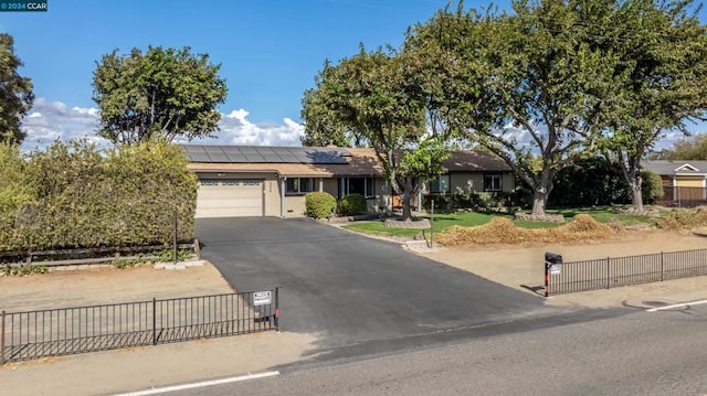 view of front of home with a garage and solar panels