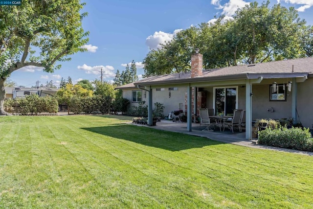 back of property with a lawn and a patio