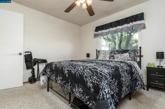 carpeted bedroom with ceiling fan and a textured ceiling