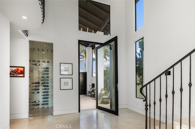 doorway to outside featuring a towering ceiling and light tile patterned floors