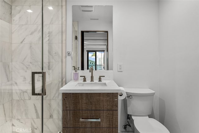 bathroom with vanity, toilet, and a shower with door