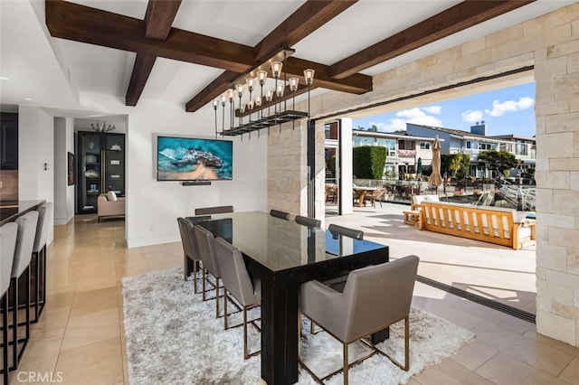 tiled dining area featuring beamed ceiling