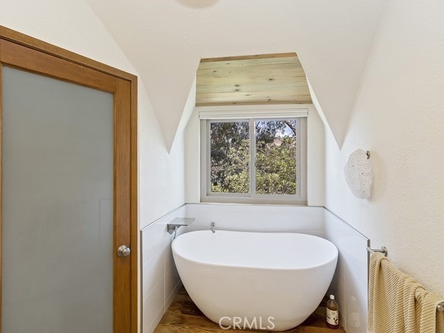 bathroom with a bathtub and tile walls