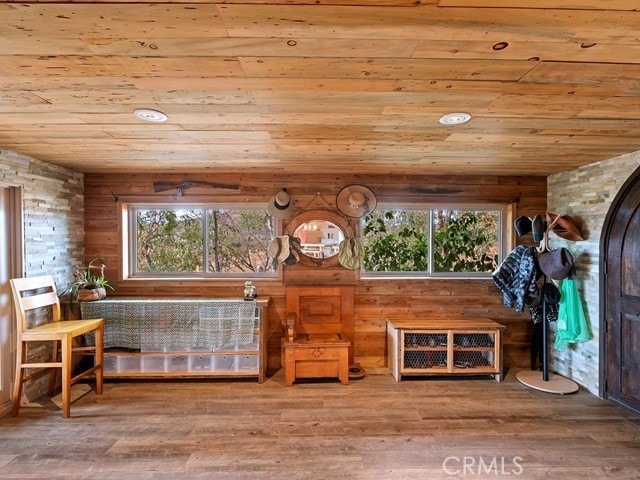 unfurnished room featuring wood ceiling, wood walls, and hardwood / wood-style floors