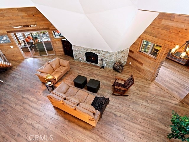 living room featuring wood walls, hardwood / wood-style flooring, and vaulted ceiling