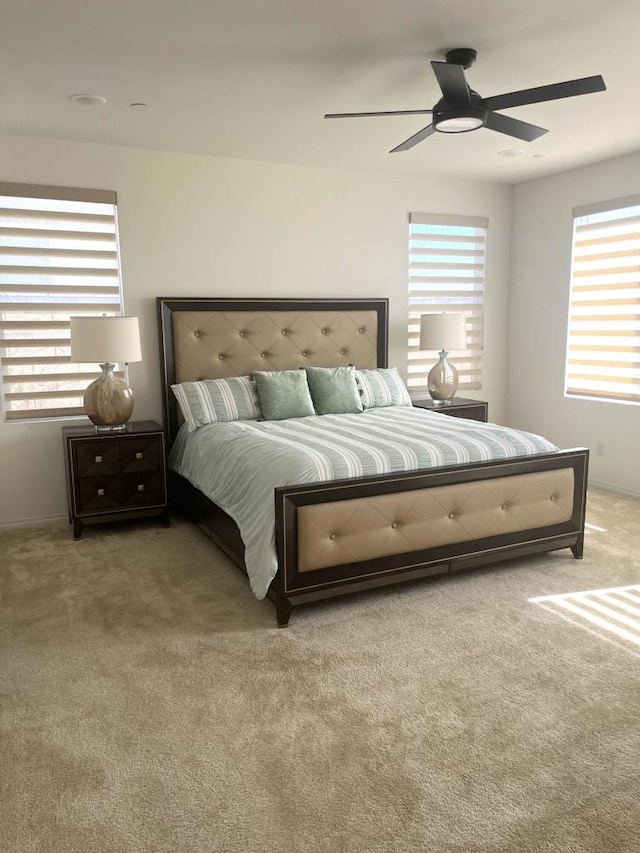 bedroom with ceiling fan and light colored carpet