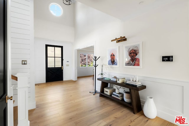 foyer featuring a towering ceiling and light wood-type flooring