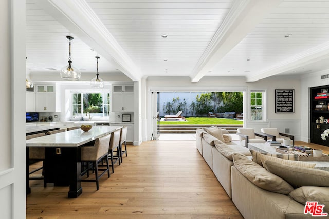 living room featuring light hardwood / wood-style floors, crown molding, beam ceiling, and a wealth of natural light