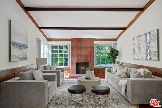 living room featuring vaulted ceiling with beams, a wealth of natural light, and a fireplace