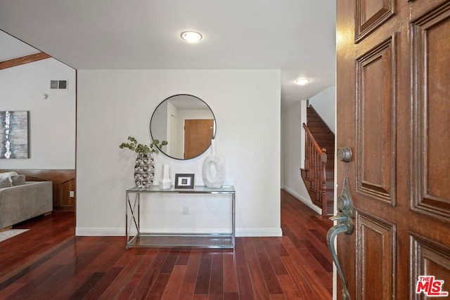 foyer with dark hardwood / wood-style floors and lofted ceiling