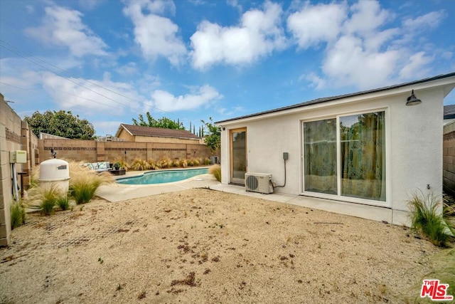 rear view of house with a fenced in pool, a patio area, and ac unit