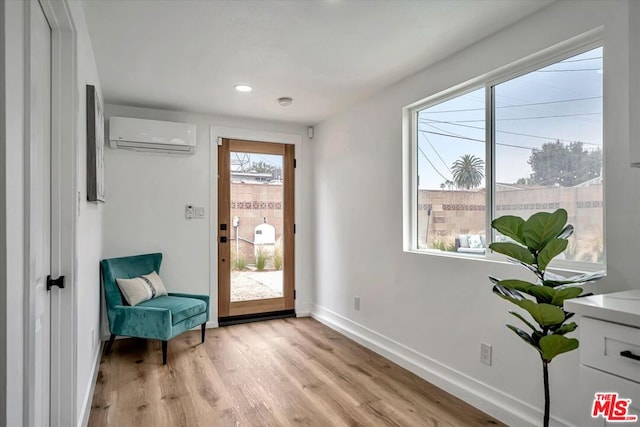 doorway featuring light wood-type flooring and an AC wall unit