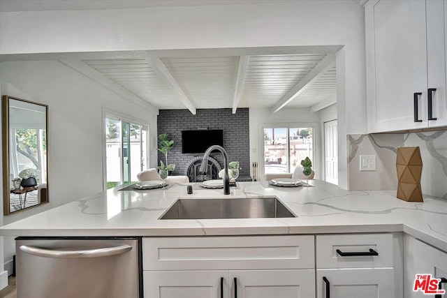 kitchen with dishwasher, sink, light stone countertops, and plenty of natural light