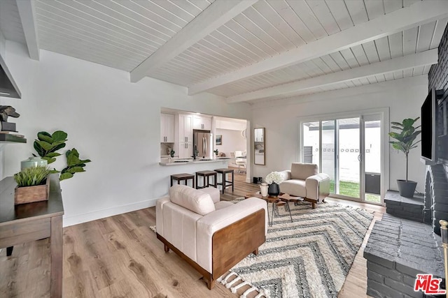 living room featuring light hardwood / wood-style floors, beam ceiling, and french doors