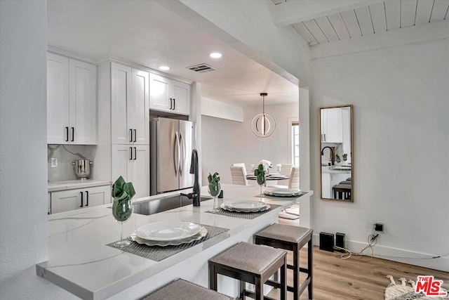 dining area with beam ceiling and light hardwood / wood-style flooring