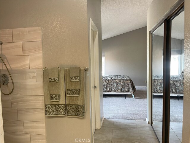 bathroom featuring a textured ceiling and lofted ceiling