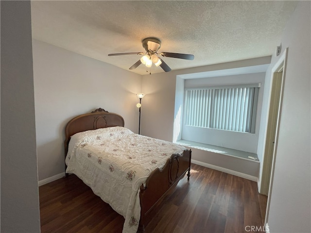 bedroom with dark wood-type flooring, a textured ceiling, and ceiling fan