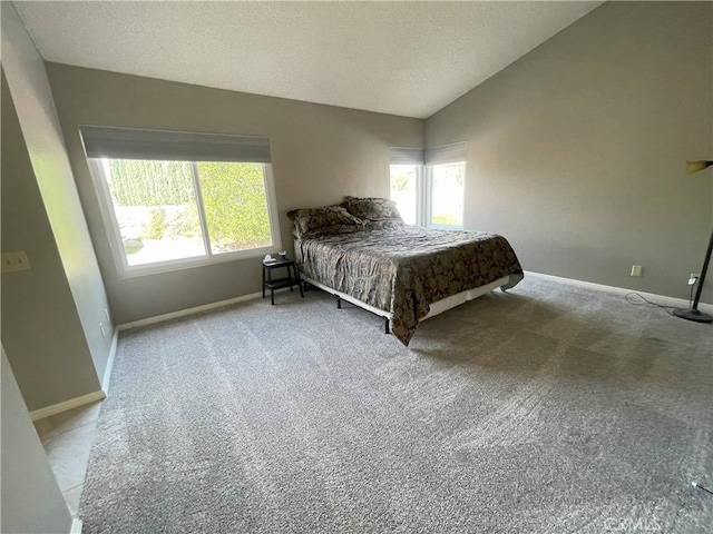 unfurnished bedroom featuring a textured ceiling, light colored carpet, and vaulted ceiling