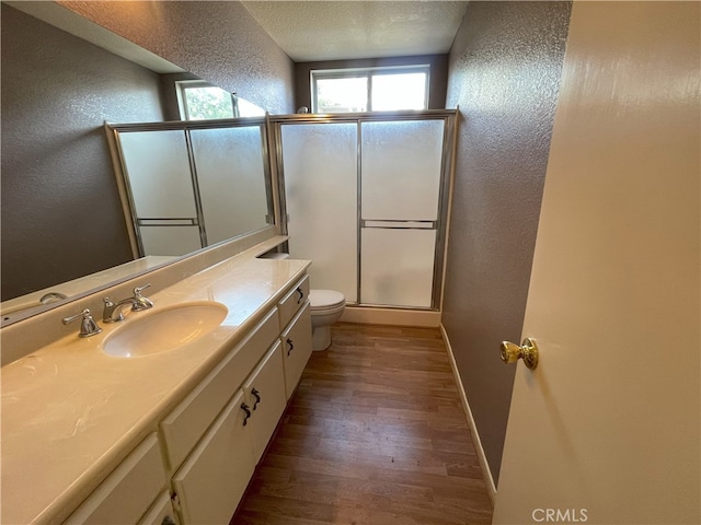 bathroom with vanity, toilet, hardwood / wood-style flooring, and a shower with shower door