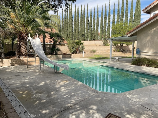 view of pool featuring a water slide and a patio area