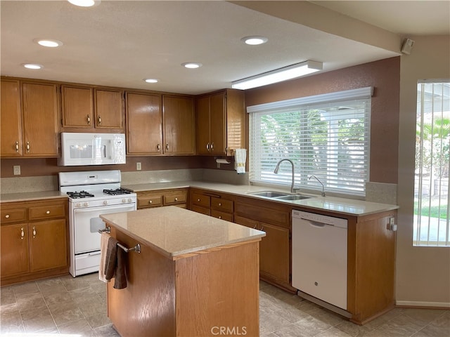 kitchen featuring white appliances, sink, and a kitchen island