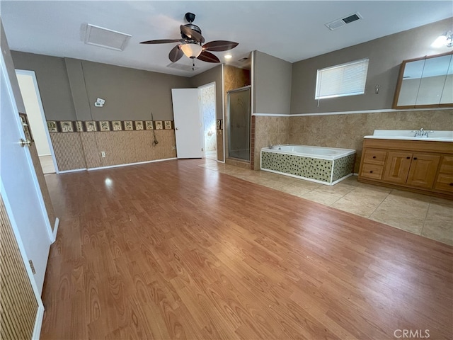 bathroom featuring vanity, ceiling fan, hardwood / wood-style flooring, and plus walk in shower