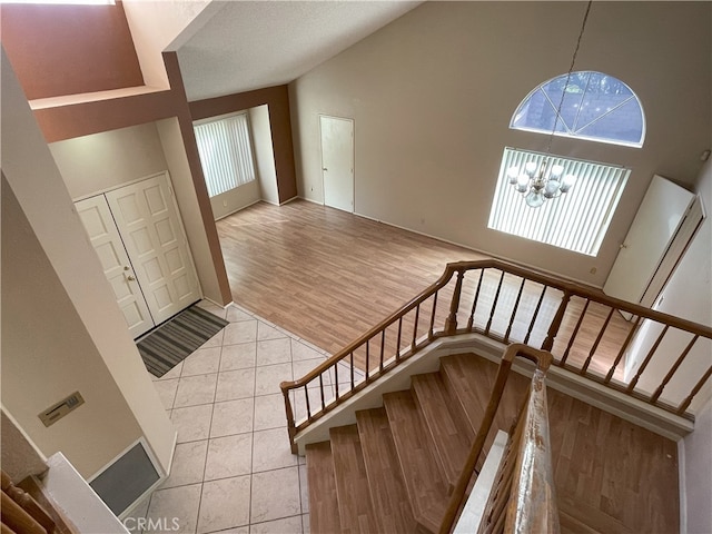 entrance foyer featuring a notable chandelier, high vaulted ceiling, and light wood-type flooring