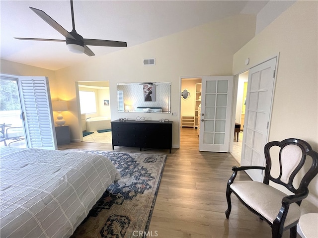 bedroom featuring ceiling fan, hardwood / wood-style flooring, vaulted ceiling, and multiple windows