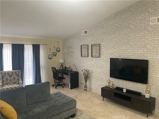 tiled living room featuring brick wall and lofted ceiling