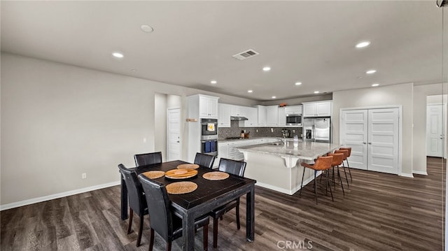 dining room featuring sink and dark hardwood / wood-style flooring