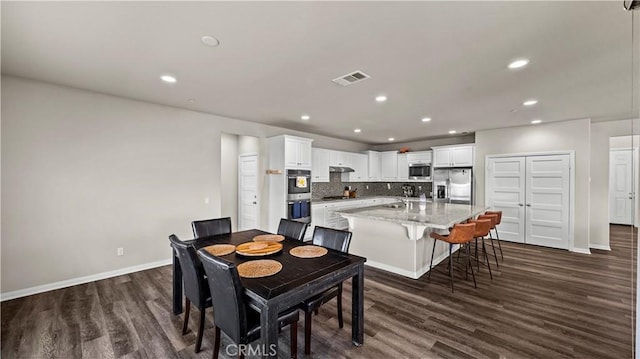 dining space featuring sink and dark hardwood / wood-style flooring