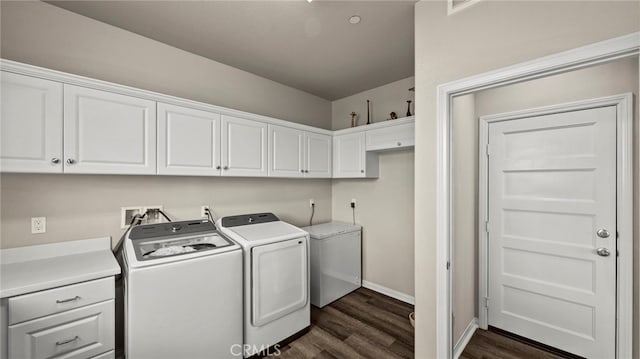 washroom featuring dark hardwood / wood-style floors, washing machine and clothes dryer, and cabinets