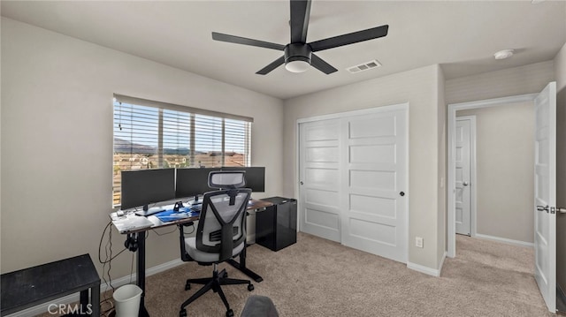 carpeted office space with ceiling fan