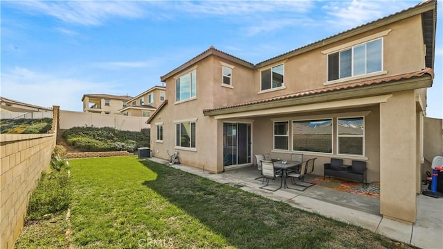 rear view of house featuring a patio area, central AC, and a yard