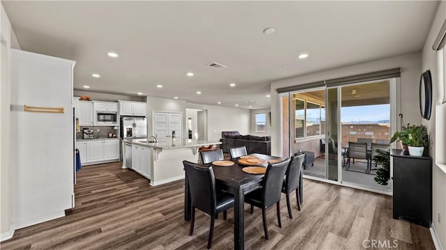 dining space with sink and wood-type flooring