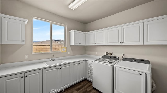 laundry room with dark hardwood / wood-style flooring, sink, separate washer and dryer, and cabinets