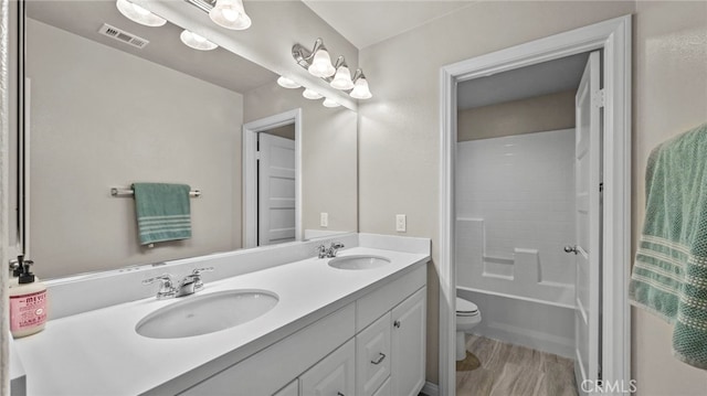 full bathroom featuring hardwood / wood-style flooring, shower / bathing tub combination, toilet, and vanity