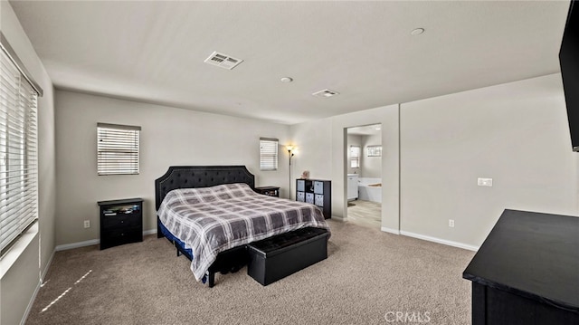 bedroom featuring ensuite bathroom and carpet