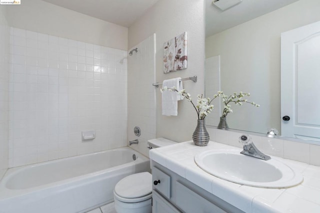 full bathroom with vanity, tiled shower / bath combo, and toilet