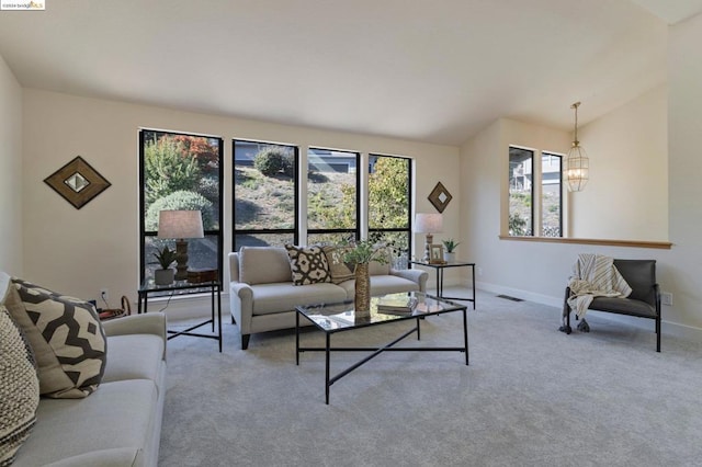 carpeted living room with plenty of natural light and lofted ceiling