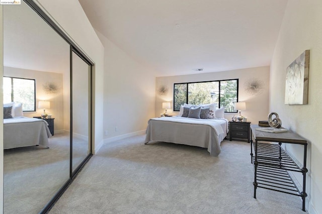 carpeted bedroom with vaulted ceiling and a closet