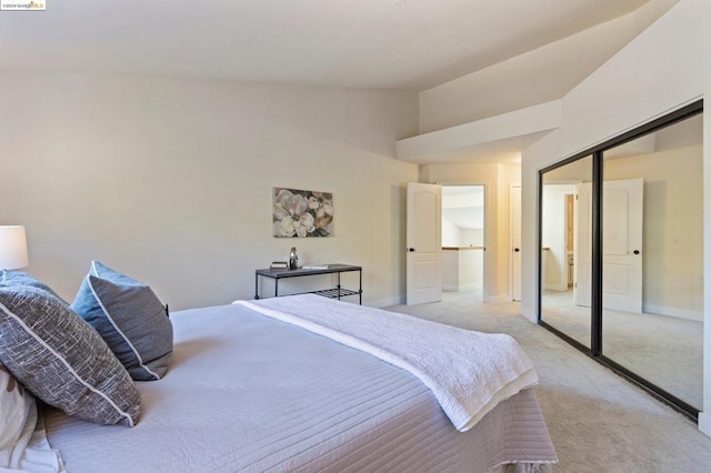 carpeted bedroom with lofted ceiling and a closet