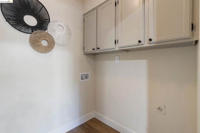 clothes washing area with cabinets, washer hookup, and dark hardwood / wood-style floors