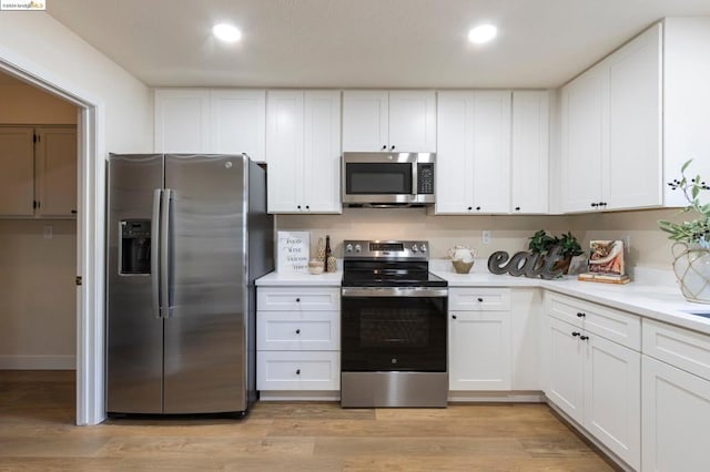 kitchen featuring light hardwood / wood-style floors, white cabinetry, and appliances with stainless steel finishes